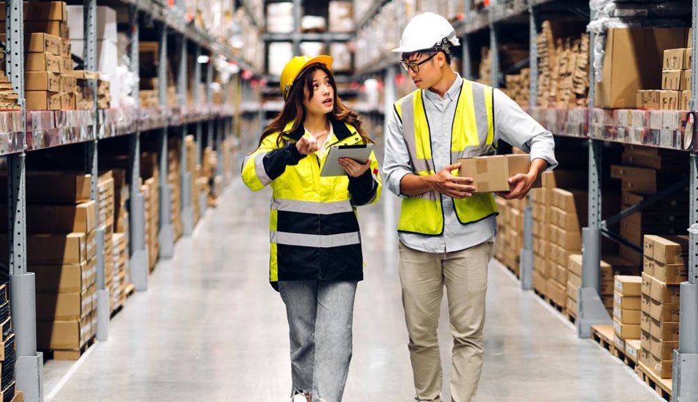 Two workers in hard hats inspecting a warehouse