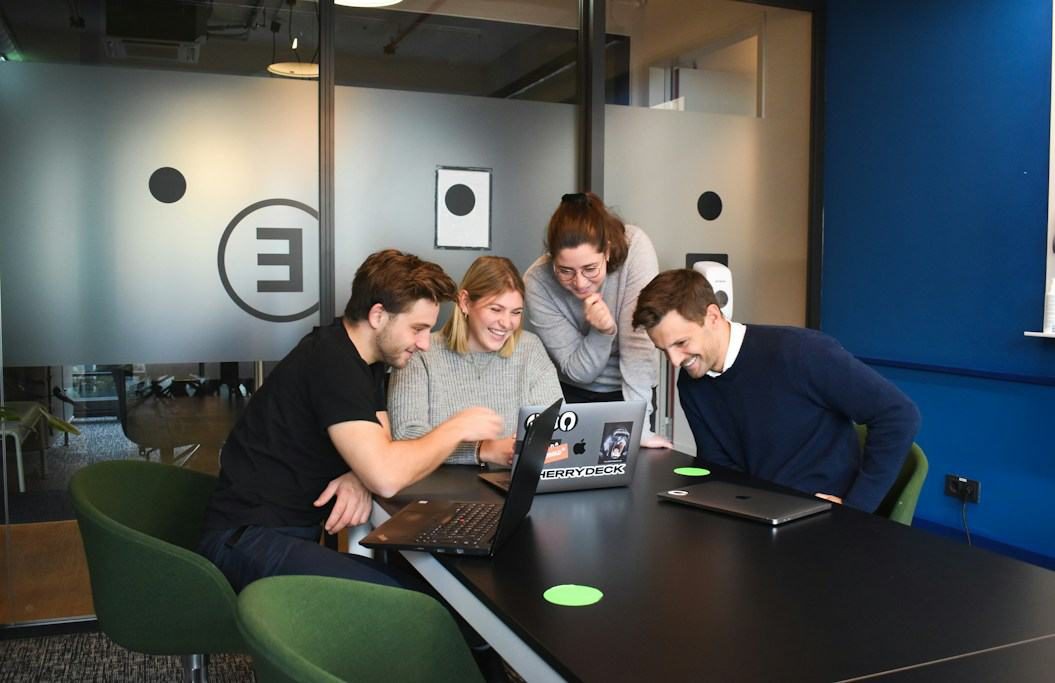 The Type M team reviewing work around a laptop